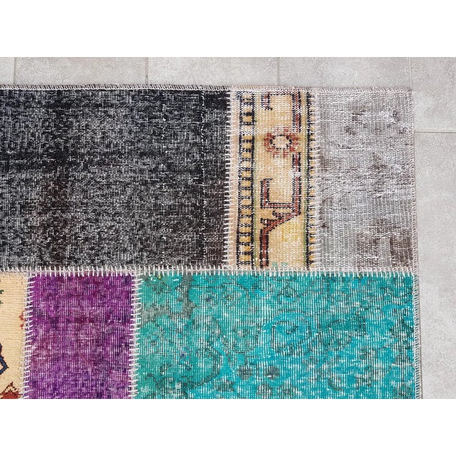 This is a vintage Turkish Oushak rug from the Mid 20th Century. The piece was hand-knotted.