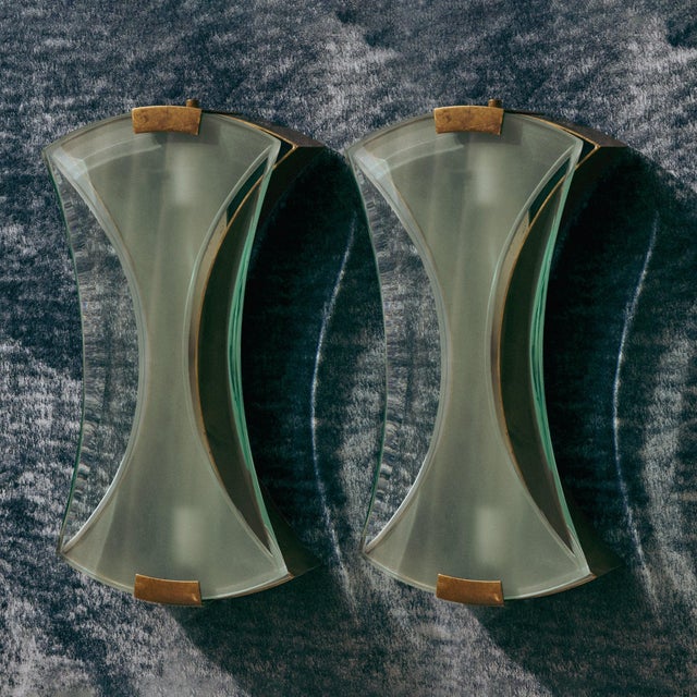 A pair of Italian ‘Model 2225’ wall sconces designed by Max Ingrand for Fontana Arte in the 1960s. Each sconce is composed...