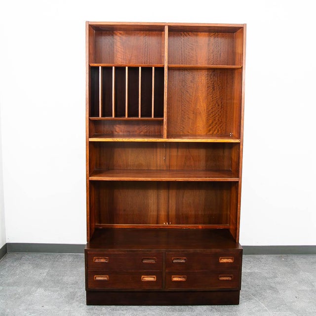 Two piece rosewood shelving unit designed by Poul Hundevad. The bottom offers 4 drawers while the top offers vinyl storage...