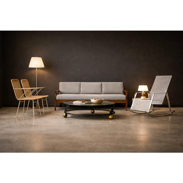 This pair of armchairs is defined by its economy of line and material restraint. A slender metal frame establishes the...
