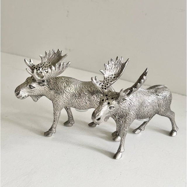 A sculptural pair of St. Anton pewter moose salt and pepper shakers by Zodax. Each walking bull moose is cast with...