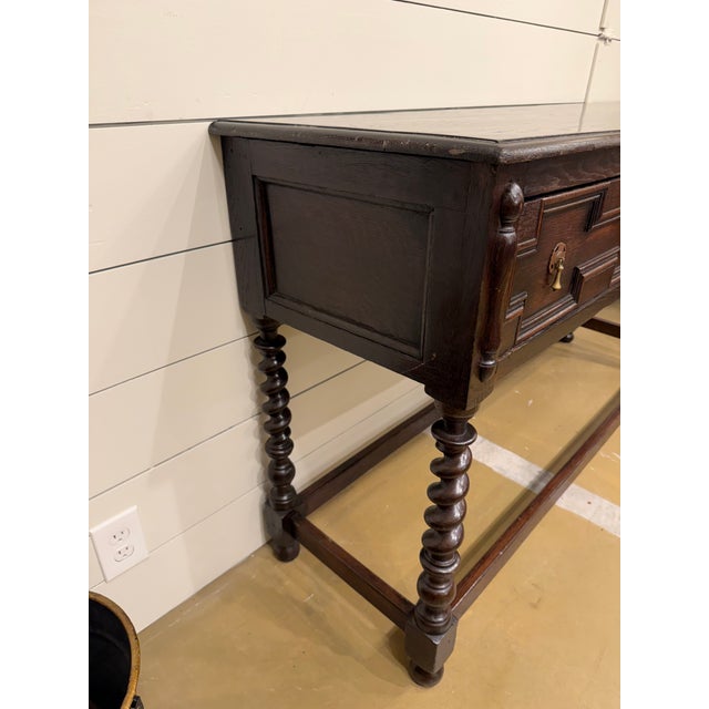 This gorgeous 19th century Jacobean dresser base server with amazing detail from carved wooden drawers to the hand forged...