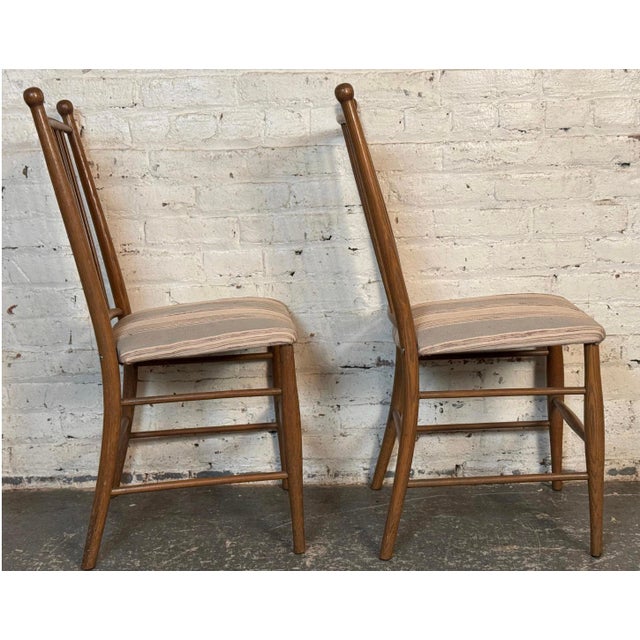 These chairs feature original striped upholstered seating and solid walnut construction. The attractive spindle backs make...
