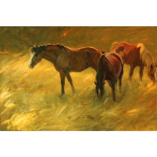 The painting depicts a serene scene of horses grazing in a sunlit field, their forms softly illuminated against a warm,...