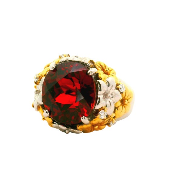 A striking ring crafted from 18k yellow gold and platinum. The centerpiece is an 8.41-carat oval rose-cut garnet,...