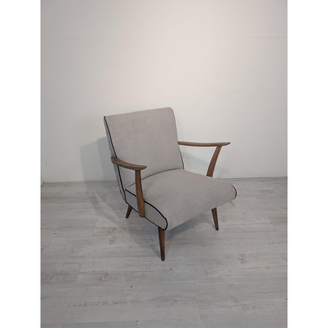 Mid-Century Scandinavian Armchair This stylish mid-20th-century Scandinavian armchair features dark wooden legs and an...