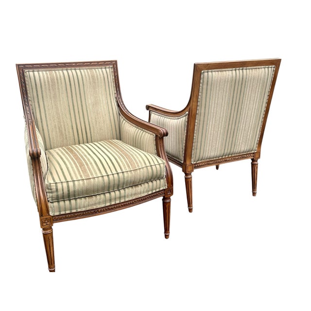 A fabulous pair of Louis xvi style carved bergere lounge chairs. Well carved walnut frames on tapered fluted leg. Ethan...