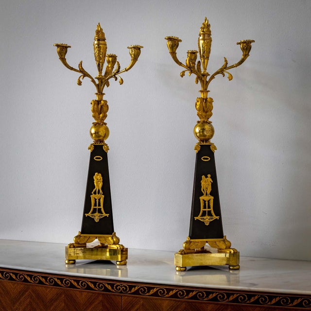 Pair of girandoles with three-flame candelabra made of fire-gilt and burnished bronze. The candlesticks stand on a three-...