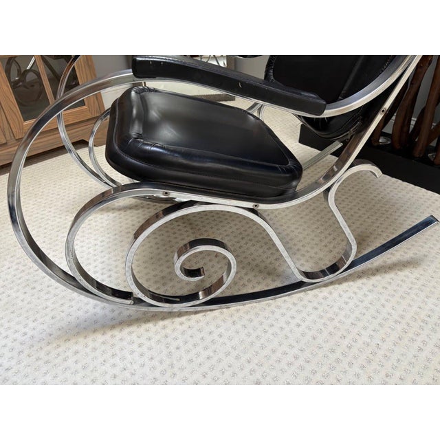 Step back into the golden age of modernist design with this stunning chrome scroll-base rocking chair, a quintessential...