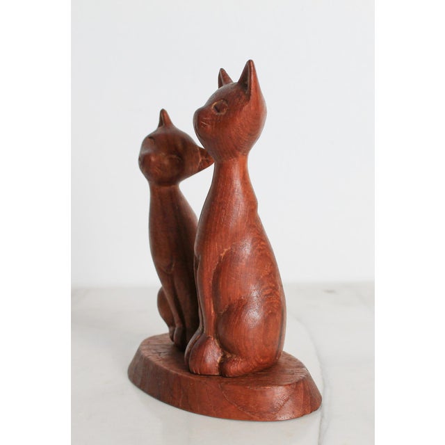 Vintage hand-carved wooden Siamese cat figurine set on a base. No makers mark. Some age wear. Pictured.
