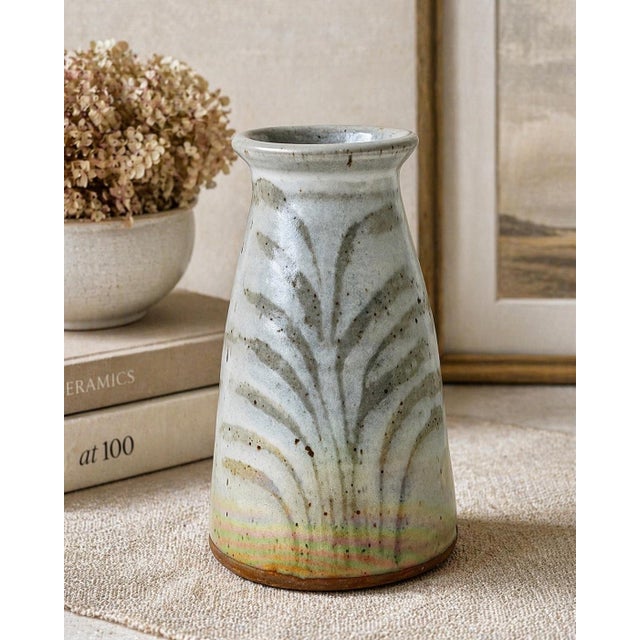 Hand-thrown studio pottery vase featuring a carved botanical motif and a soft matte glaze with subtle iridescent...