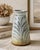 Hand-thrown studio pottery vase featuring a carved botanical motif and a soft matte glaze with subtle iridescent...