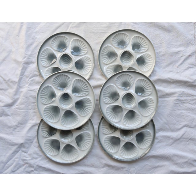 Set of 6 earthenware oyster plates by Moulin des Loups. Each plate features 6 shell holders and a central circle, in a...