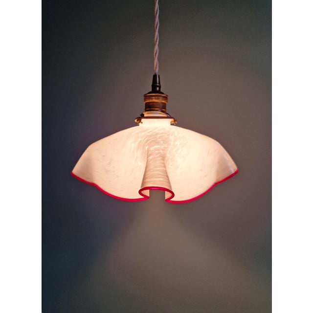 Art Deco pendant light in white speckled pleated glass with a burgundy rim, 1930s. The pendant light has been rewired and...