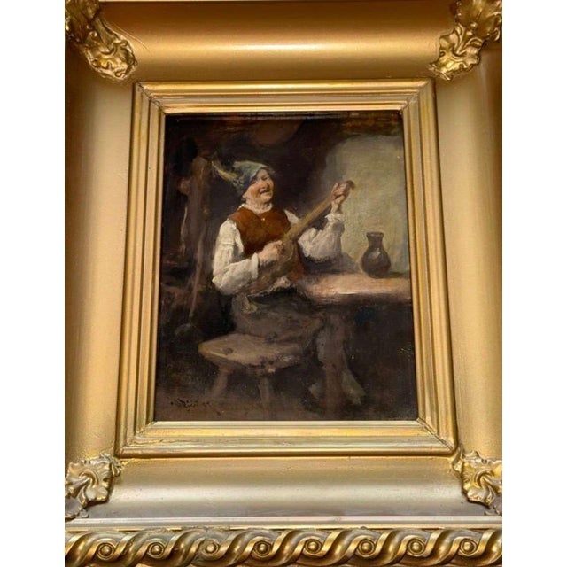 Charming early 19th-century Dutch genre scene depicting a seated musician in a rustic interior, playing a stringed...