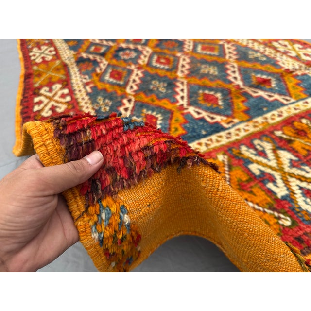 This is a Moroccan Berber tribal rug, hand-knotted with wool. It features bold tribal diamond motifs in deep red, blue,...