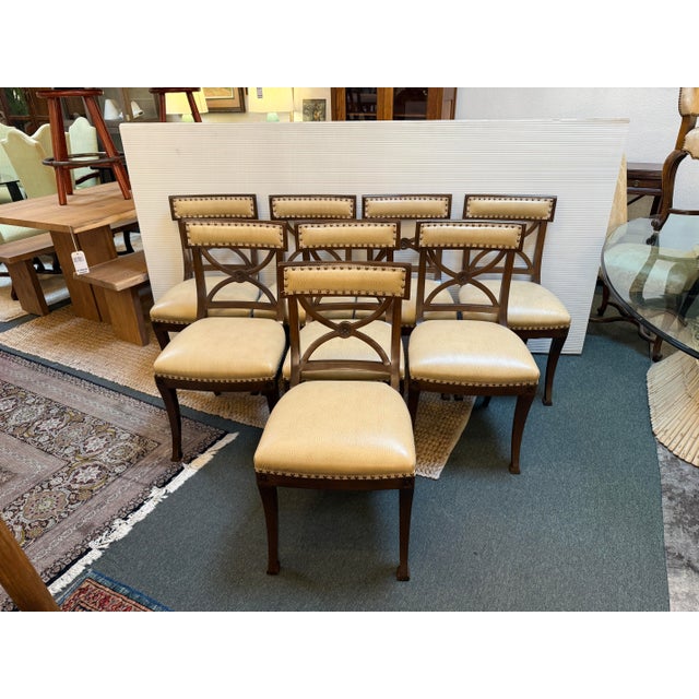 Design Plus Gallery present a Set of Eight Mahogany Dining Chairs by Schumacher. The chairs take on a French Empire...