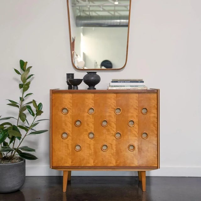 A mid-century cabinet No. U-450 designed by Jiří Jiroutek made of ash, birch, fabric, and steel. The cabinet features a...