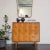 A mid-century cabinet No. U-450 designed by Jiří Jiroutek made of ash, birch, fabric, and steel. The cabinet features a...
