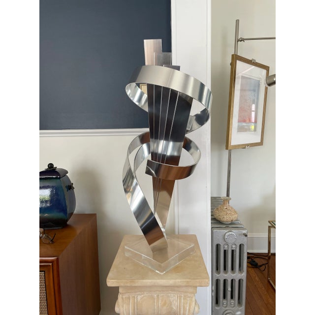 Spectacular presence with this Ribbon Sculpture by Dan Murphy. Unique design with 5 fanned ribbons encircled by a 2 ribbon...