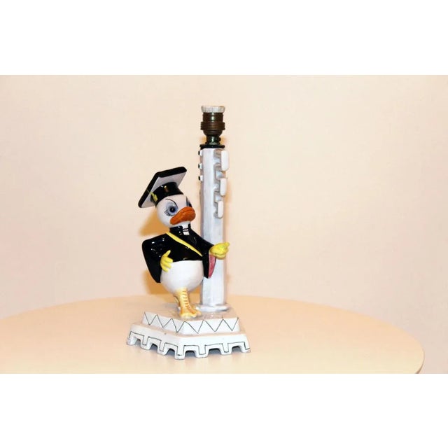 - Painted porcelain table lamp - Features a fabric screen - Figure from the Disney family - Signed on the bottom...
