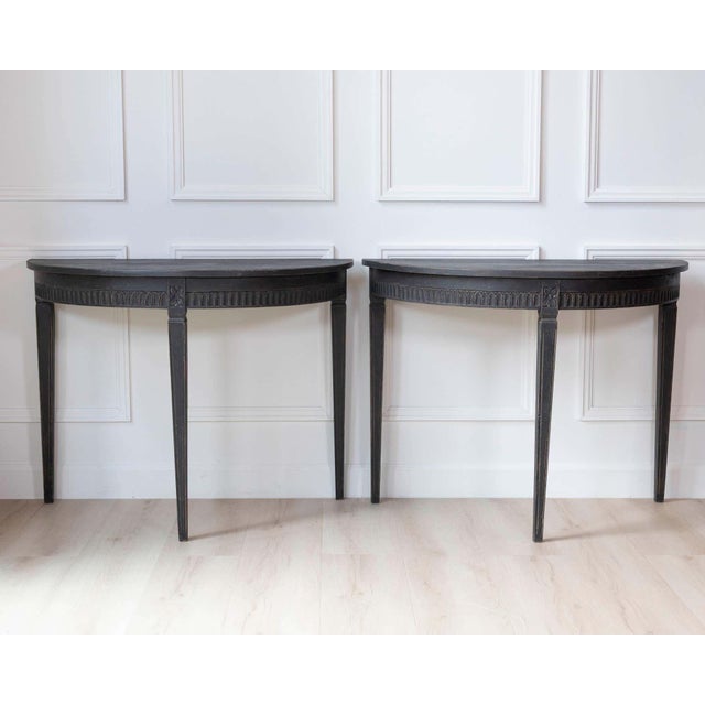 A handsome pair of Swedish demi-lune tables dating to the latter half of the 19th century. Each table features the classic...