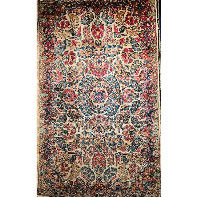 This elegant vintage Persian Kerman Lavar rug from the early 1900s features a harmonious all-over floral bouquet pattern,...