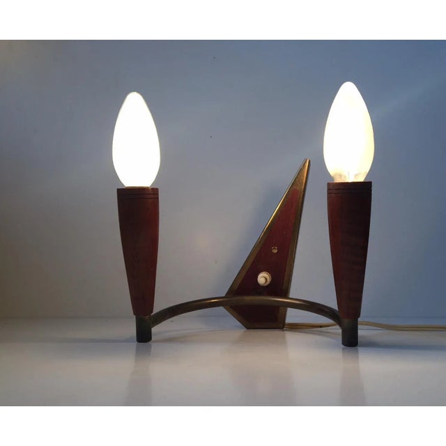 This sconce comes with two light sources and is made of teak and brass. The sconce can rotate and is adjustable. It was...