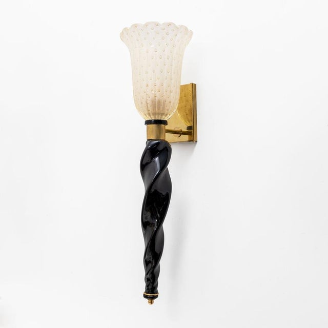 An elegant pair of Murano glass sconces, an expression of the refined art of Venetian glassmaking. The hand-blown glass...