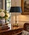A classic bouillotte lamp rendered in warm brass, distinguished by its clean, tailored black tole shade. The form traces...