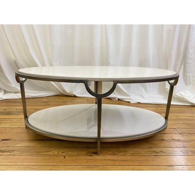 Bernhardt Morello cocktail table featuring a faux Carrara marble top and steel frame in a nickel finish. This oval-shaped...