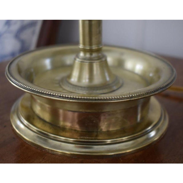 French 19th century brass and tin bouillotte lamp. The black painted tole shade is detailed with a gilt floral rim. Now...