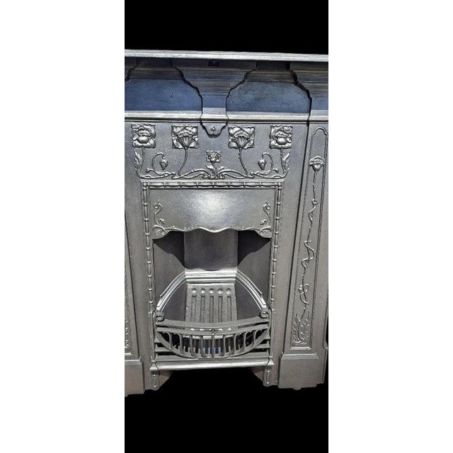 A striking original antique Art Nouveau cast iron combination fireplace, richly decorated with stylised floral motifs...