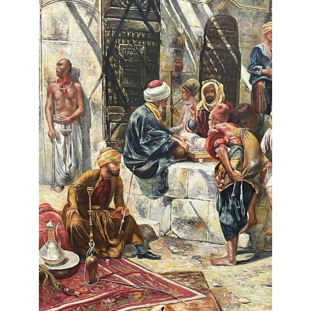 Large Orientalist Painting in a similar style as "A street In Cairo" by artist Ettore Simonetti (1857-1909). The artwork...