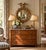 A Federal-style giltwood convex mirror crowned with a carved eagle, its wings outstretched above a laurel motif—an...
