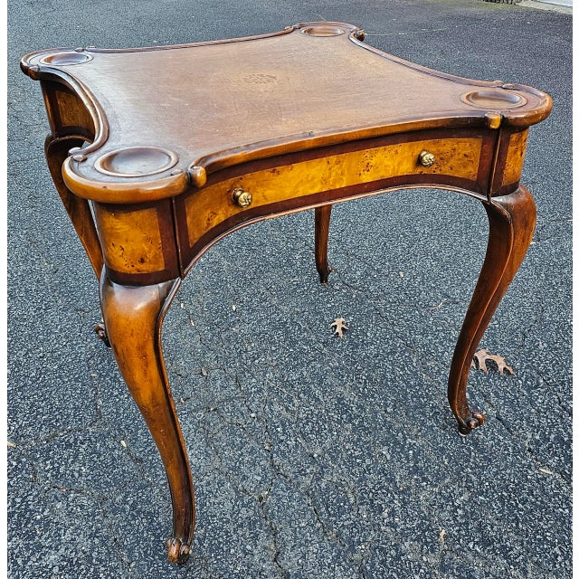 This Theodore Alexander Tooled Leather Top Game Table features a beautiful tooled leather top with intricate markings and...