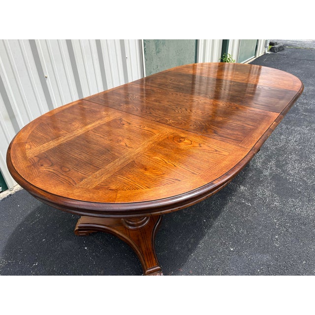 Double pedestal oak extension dining table. Includes two 18” leaves and can expand from a 52”circular shape to 88” oval...