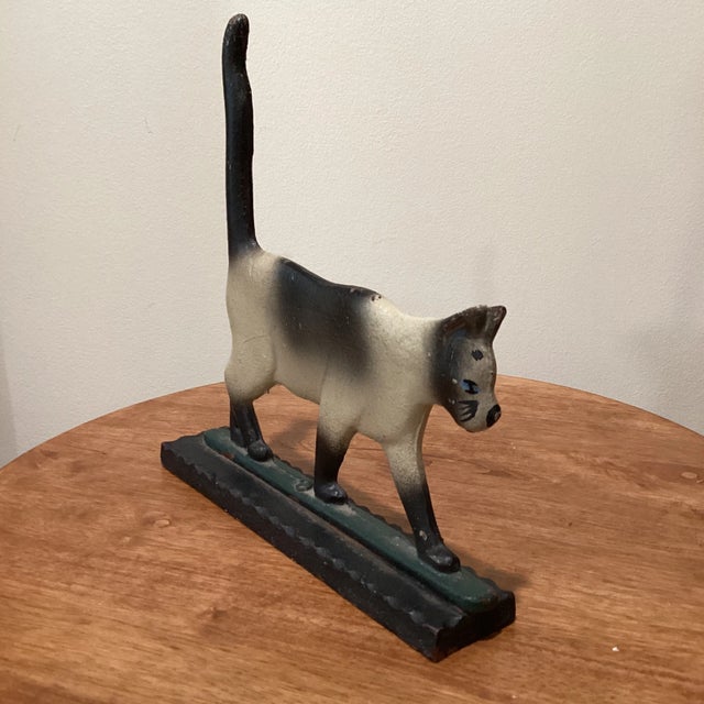 Old cast iron cat figure doorstop. A figural kitty kat,top bolted down onto bottom base, multicolored.