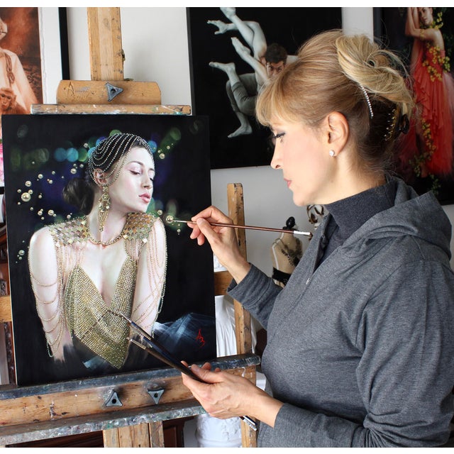 This artwork features a serene figure adorned in shimmering gold embellishments, exuding an air of elegance and...