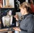 This artwork features a serene figure adorned in shimmering gold embellishments, exuding an air of elegance and...