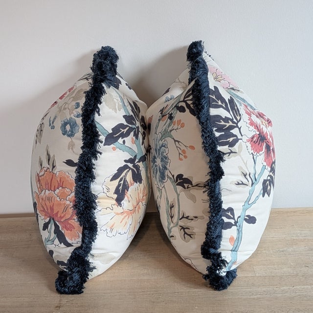 Lee Jofa Inisfree floral pillows in sunset, featuring brigh orange, coral, medium blues and teals. Different print layout...