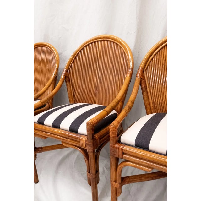 Set of four vintage chairs featuring bamboo frames and distinctive rounded caned backrests. The seats have been completely...