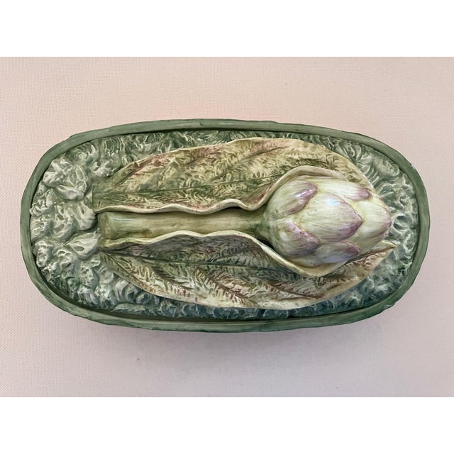 An Italian Majolica lidded tureen embellished with hand-painted burgundy radishes with green leaves. The domed lid is...