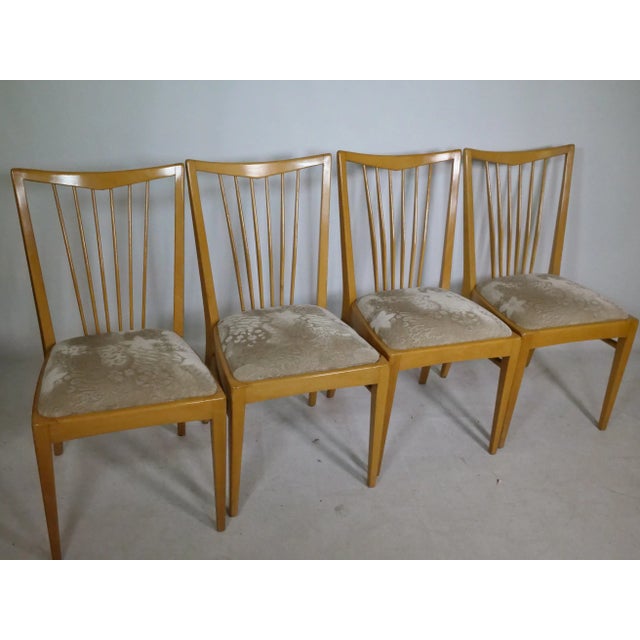 Mid-century design wooden dining chairs from the 1960s. The chairs feature a simple backrest with vertical slats and...