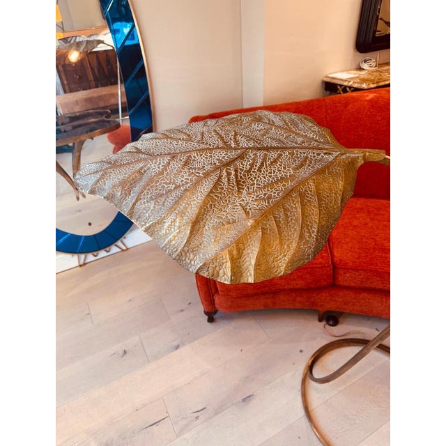 An original large floor lamp with three adjustable patinated brass rhubarb leaf mounted on stems with a circular base all...