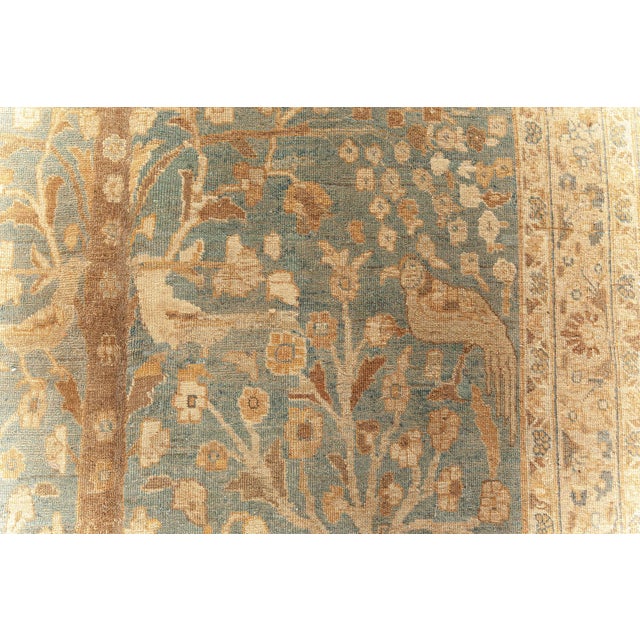 This circa-1920 antique Persian carpet features an all-over design of a garden vignette with exotic birds and bunches of...