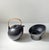Black teapot and stand/warmer in glazed ceramics. Stylish organically shaped teapot in an ovoid form and with a practical...