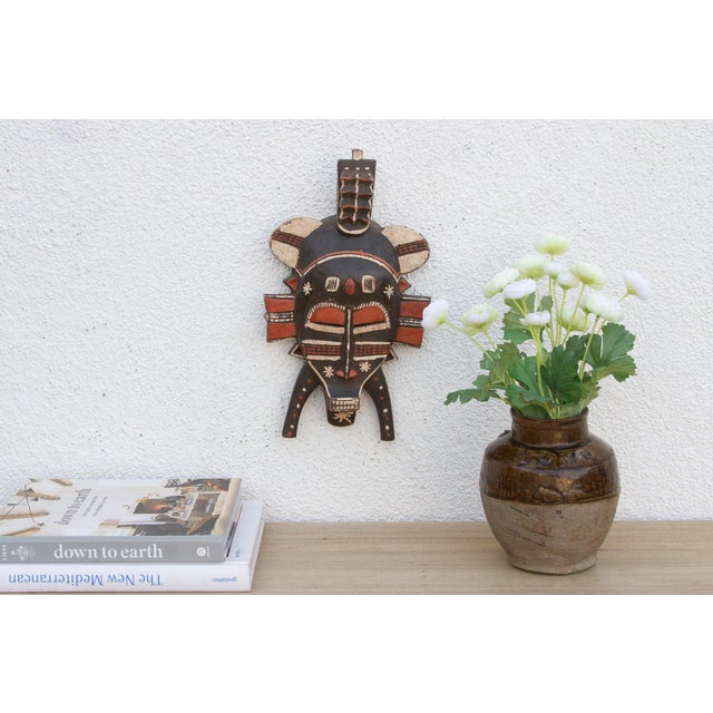 This striking mask, with its bold geometric patterns and avian-inspired design, speaks of a rich cultural heritage and...