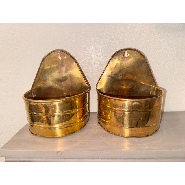 A beautiful matching pair of vintage mid-century solid brass wall pocket planters. Featuring a clean, minimalist semi-...