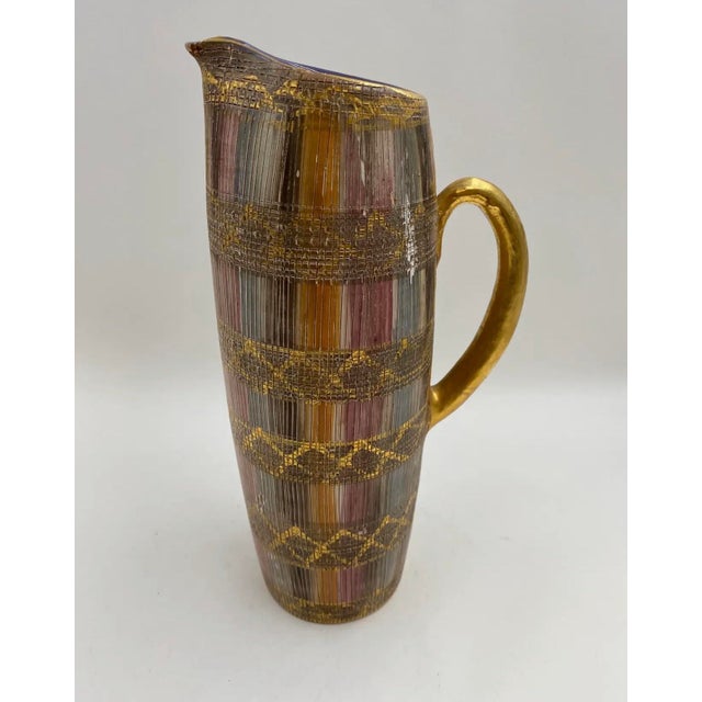 A beautifully textured “Seta” pitcher by Aldo Londi for Bitossi, featuring layered bands of warm metallic tones and...